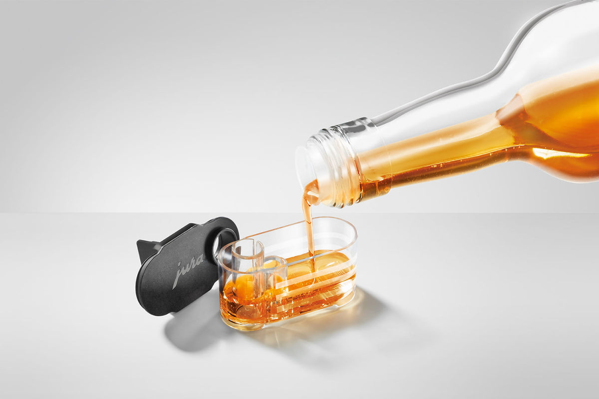 JURA Sirupaufsatz wird mit Sirup befüllt