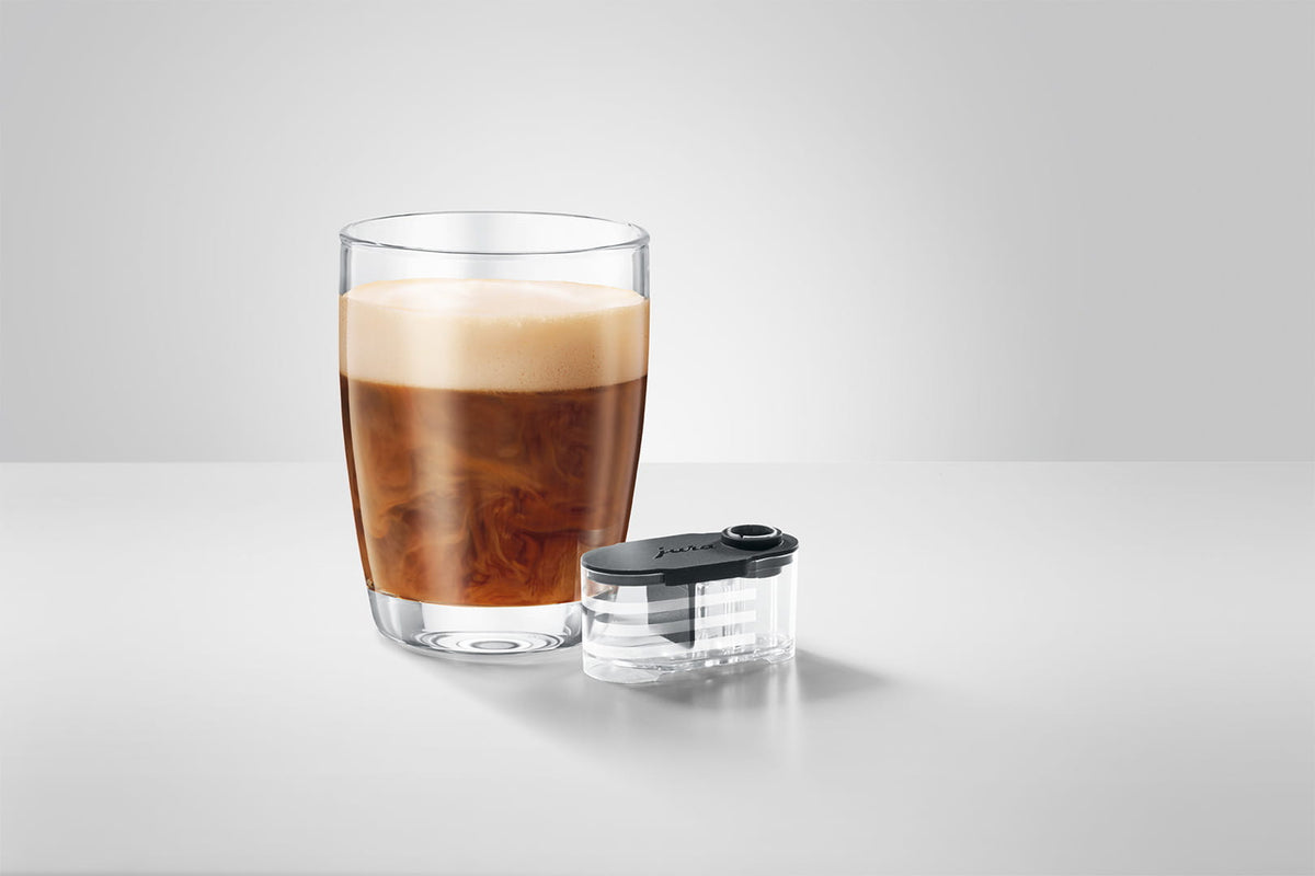 JURA Sirupaufsatz 25064 neben einem Glas Kaffeespezialität