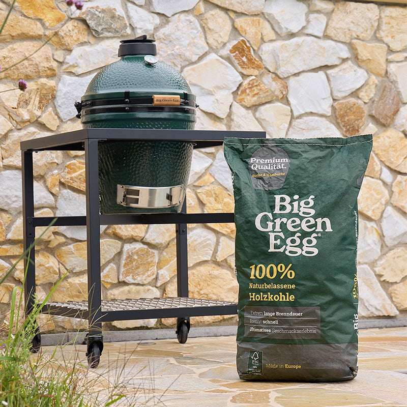 Big Green Egg Holzkohle-Sack neben einem EGG im Gestell